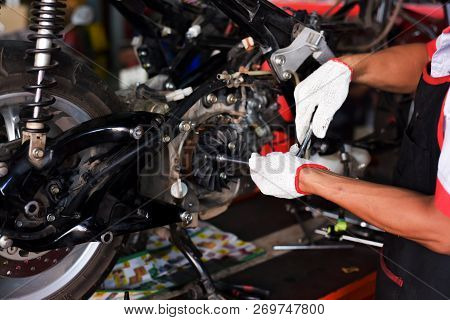 Mechanic Using A Wrench And Socket On The Engine Of A Motorcycle