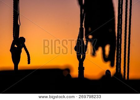 Ropes, Nets, Cables, Pulleys And Bollards As Shadows Against A Colorful Sky Of Red And Blue Colors O