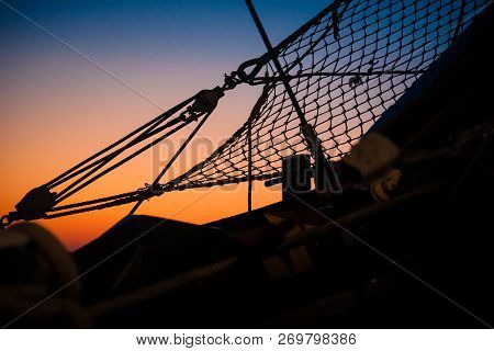 Ropes, Nets, Cables, Pulleys And Bollards As Shadows Against A Colorful Sky Of Red And Blue Colors O