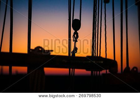 Ropes, Nets, Cables, Pulleys And Bollards As Shadows Against A Colorful Sky Of Red And Blue Colors O