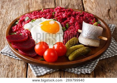 Traditional Meal Of Northern Germany Labskaus Of Potato, Corned Beef And Beet With Fried Egg, Pickle