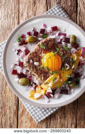 Fried Beef Tartare Or Parisian Steak - Pariserbof With Egg,  Vegetables And Mustard Close-up On A Pl