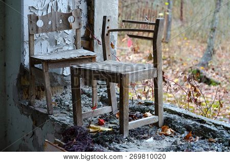 Small Wooden Chairs By Window Without Glass In Kindergarten Against Background Of Forest Overgrown S