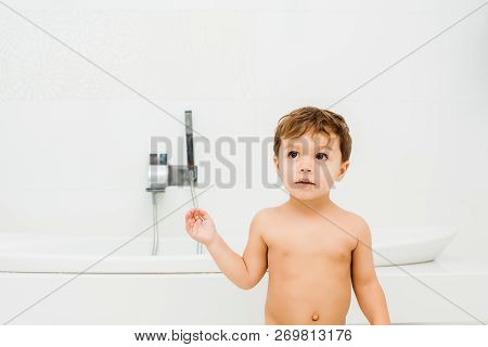 Small Boy Stainding And Looking At Something In White Bathroom