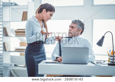 Resolute Beautiful Woman Grabbing Tie Of Her Workmate