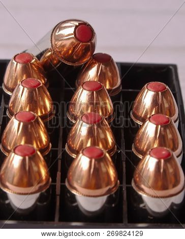 Twelve 44 Special Bullets With Red Tips In A Black Case With One Of Them On Top Of The Others Showin