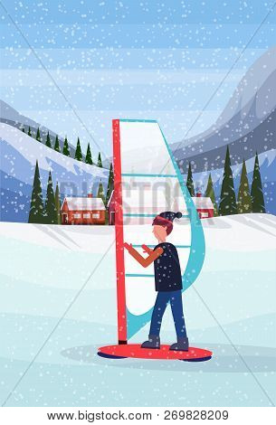 Man Windboarding Windsurfing On Snow Over Small Village Houses Winter Snowy Mountains Hills Fir Tree