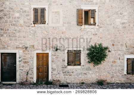 The Facade Of An Ordinary Old Building With A Door And Windows In Montenegro. Traditional Housing.