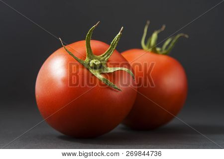Group Of Tomatoes Isolated On Black With Leaf And Stem. There Are Around 7,500 Tomato Varieties Grow