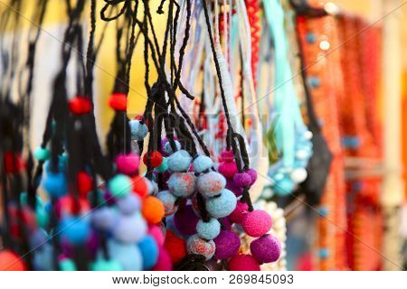 Background. Colorful Female Ornament From Threads In The Form Of Balls. Cut Off Shot, Close-up, Plac