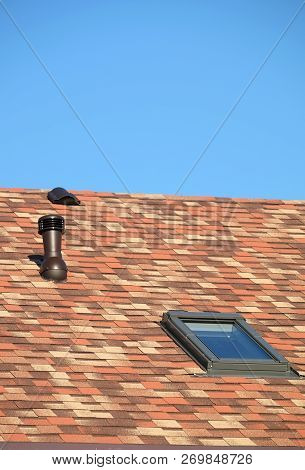 Roof Window And Ventilation Tube On Residential House Roof Covered With Motley Soft Shingles Close U