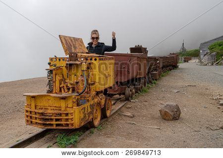 Woman Poses As A Train Conductor On A Mining Cart At Independence Mine Alaska At Hatcher Pass On A M