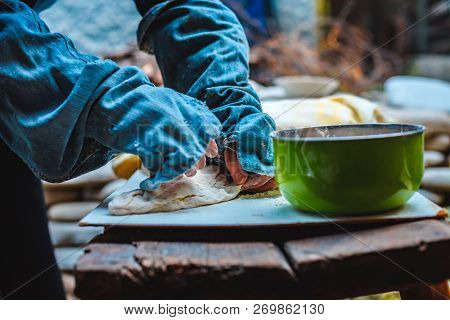 The Woman In Oversleeves Cooks Dough For Home-made Bread On Open Air