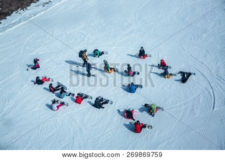 Lots Of Skiers And Snowboarders Have A Rest On A Slope At Ski Resort