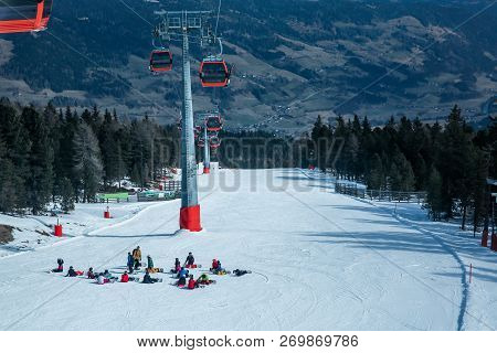 Lots Of Skiers And Snowboarders Have A Rest On A Slope At Ski Resort