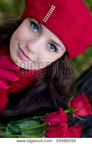 Ragazza con rose rosse nel parco