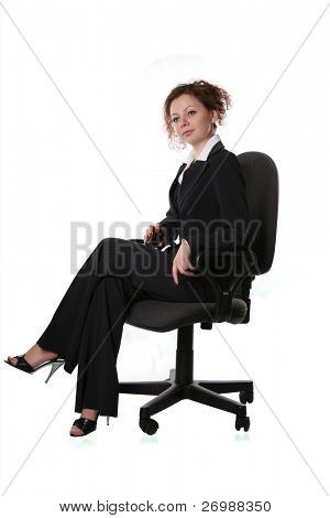 Girl with a mobile phone is sitting in an office chair