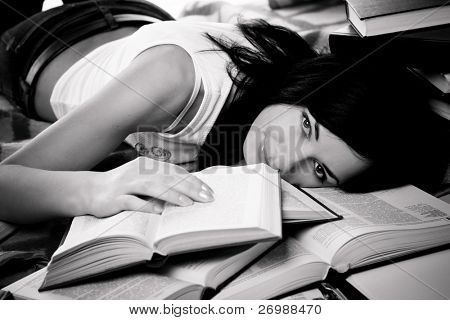 Girl lies on the floor of books