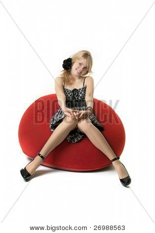 Image of the blonde girl, who sits in a red chair