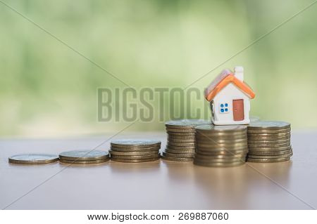 Mini House On Stack Of Coins,money And House,  Mortgage, Savings Money For Buy House And Loan To Bus
