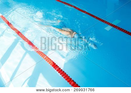 Image on top of man swimming on back in swimming pool