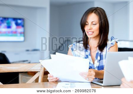Woman with papers in their living room