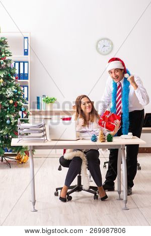 Colleagues exchaing christmas presents in office