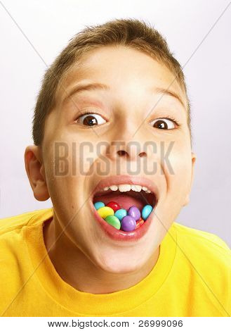 Petit garçon, manger des bonbons sur fond blanc. Petit garçon mangeant chicle.