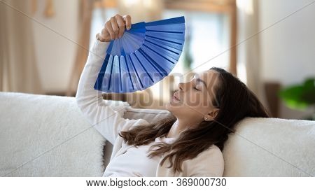 Overheated Young Woman Breathe Fresh Air From Waver