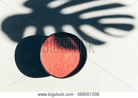 Pink Smoothie From Banana And Strawberries In The Coconut Shell Bowl, Strong Shadows. Healthy Summer