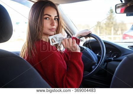 Joyful Girl Driving A Training Car With A Drivers License Card In Her Hands