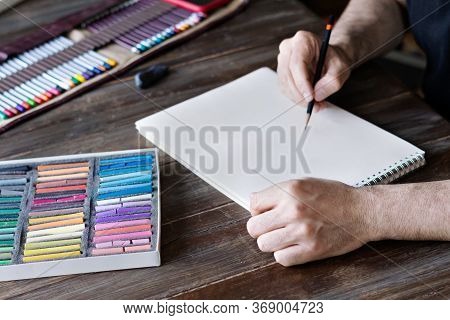 Man Painting With Color Pencil And Pastel Crayon Chalks On Paper. Box Of Pastel Chalks And Color Pen