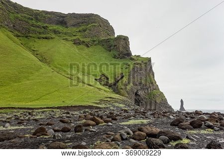 Reynisdrangar Troll Toes Stack Rocks In The Sea With Icelandic Green Landscape And Basalt Columns
