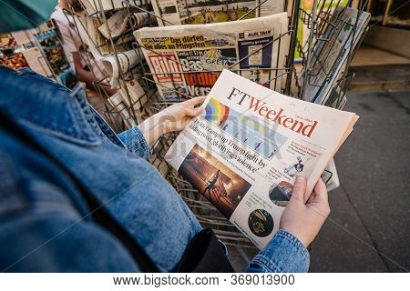 Paris, France - May 30, 2020: Pov Wman Reading At Press Kiosk Financial Times Newspaper Featuring Us