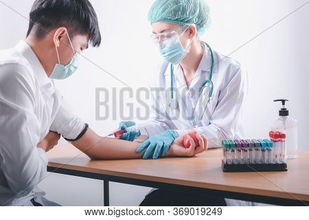 Medical Doctor Is Collecting Blood Sample Test Syringe Injection From Male Patient In Laboratory Tes