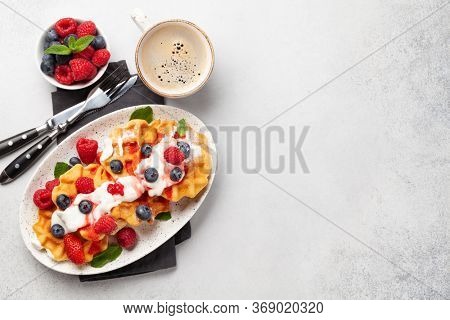Delicious belgian waffles with ice cream and summer berries and breakfast coffee. Top view with copy space