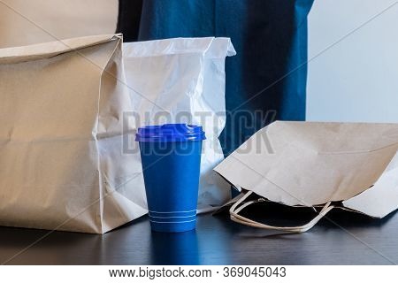 A Lot Of Craft Paper Bags And Boxes Stay On The Table With Cup Of Ccoffee. Concept Of Delivery Servi