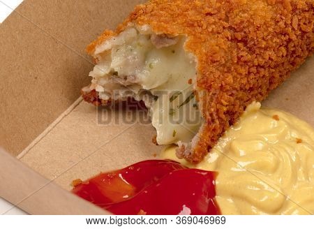 Partly Eaten Brown Crusty Dutch Kroket With Mustard And Ketchup Isolated On A White Background