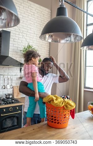 African American Man Holding His Daughter And Feeling Uncertain