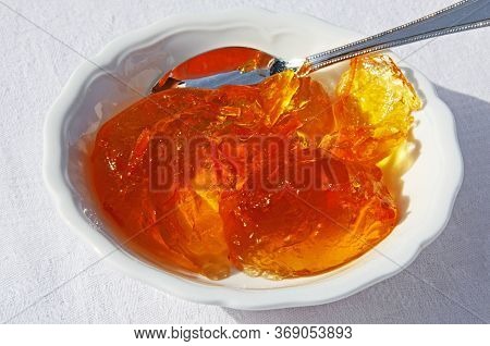 Orange Marmalade In A White Ceramic Dish With A Silver Spoon.