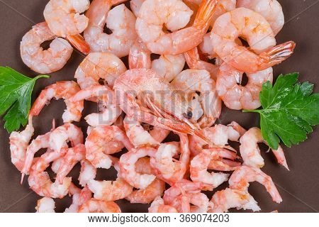 Cooked Peeled Tails Of King Prawns And Usual Shrimps On The Brown Dish, Fragment Top View, Backgroun