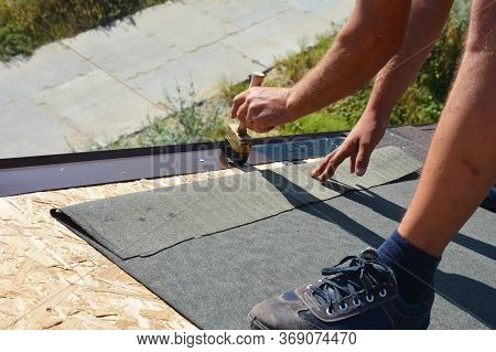 A Building Contractor Is Installing Underlayment, A Layer Of Bitumen Tape On Sheathing For Overall R