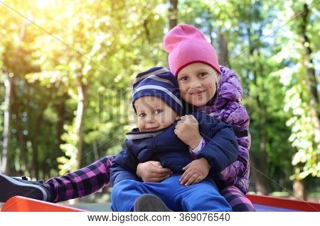 Two Cute Adorable Playful Caucasian Siblings Boy Girl Child Enjoy Havefun On Playground At Backyard 