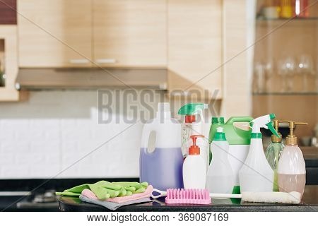 Set For House Cleaning: Plastic Bottles With Detergents And Disinfecting Sprays On Kitchen Counter W