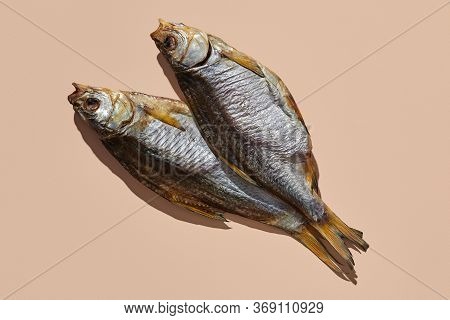 Two Dried Or Jerky Salty Taranka, Yummy Clipfish On Pink Background. Popular Beer Appetizer. Traditi