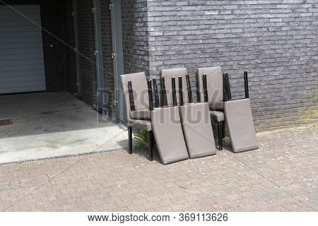 Dumped Six Worn And Old Chairs Against The Facade Of A House