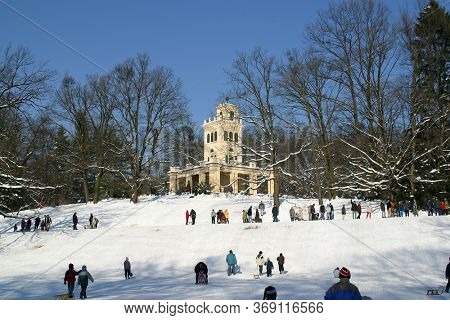 ZAGREB, CROATIA - JANUARY 12, 2014: Landscape view of a snowy hill with families with children and people sledging and having fun in snow, Park Maksimir in Zagreb, Croatia