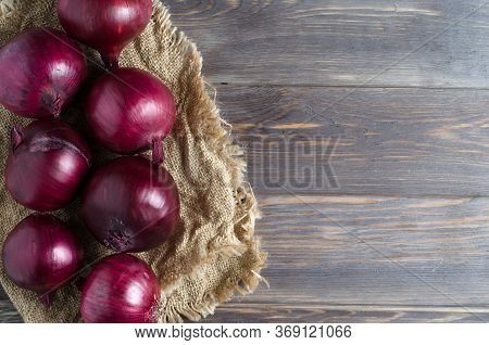 Red Onions On Old Crumpled Burlap. Copy Space