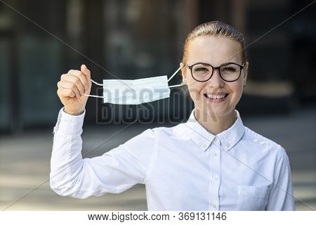 Happy Positive Girl, Young Beautiful Woman, Businesswoman Takes Off Protective Sterile Medical Mask 