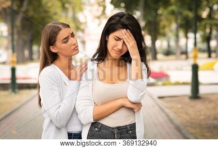 Friendship And Support. Compassionate Girl Comforting Desperate Female Friend Standing Outdoor In Pa